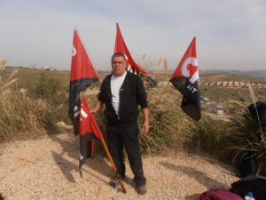 Una persona posa en el campo junto a cuatro banderas de la CNT